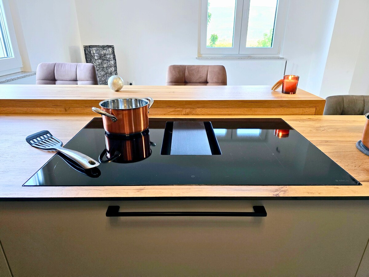 Induktionskochfeld mit Kupfertopf und integriertem Dunstabzug